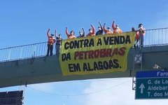 trabalhadores que empunhavam uma faixa manifestando posição contrária dos petroleiros à venda dos campos da Petrobras no estado; Foto: Reprodução