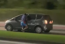 Vídeo: homem é flagrado pendurado na janela de carro em movimento