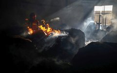 Bombeiro tenta extinguir incêndio dentro do prédio de fábrica em Rupganj