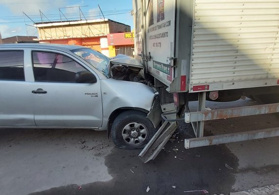 Carro colide na traseira de caminhão estacionado e motorista fica ferido