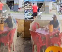 Cliente usa mosquiteiro para beber cerveja em bar em Alagoas