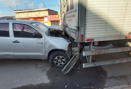 Carro colide na traseira de caminhão estacionado e motorista fica ferido