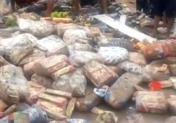 Pessoas se amontoam em busca de alimentos estragados pela chuva em Rio Largo